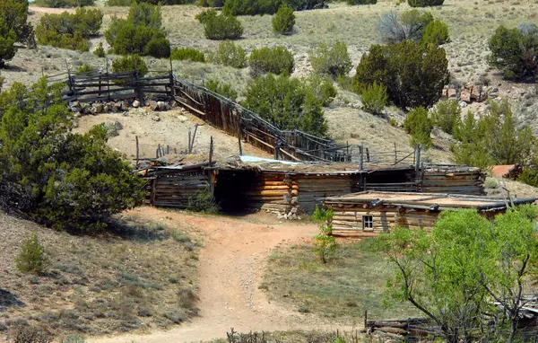 Stock image Old rustic farm includes pole corral, cabin and sheds.  Dirt road leads to buildings and meanders between them.  Buildings are part of the El Rancho de las Golandrinas museum.