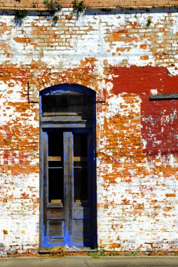 Background image shows old blue door surrounded by aging, orange bricks.  Business has closed and time has worn paint and wood. clipart