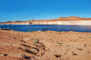 Tekne, Arizona 'daki Glen Canyon Ulusal Eğlence Bölgesi' nin güzel kumtaşı kayaları ve uçurumları boyunca kenetlenmiştir..  