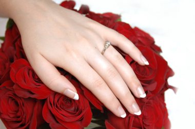 Yakından bakınca gelininin ince ve zarif elinin kırmızı gül buketinin üzerinde yattığını görüyoruz..  