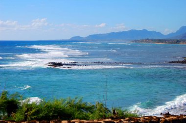 Aqua mavi suları ve yumuşak dalgalar Hawaii, Kauai adasındaki manzarayı doldurur..