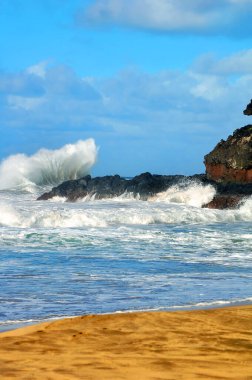 Güçlü bir dalganın Hawaii, Kauai 'deki Lumaha' i Sahili 'ndeki kayalara çarpmasıyla büyük bir sıçrama oluşur..
