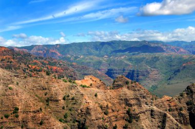 Red soil of Waimea Canyon State Park shows from the erosion of wind and rain.  Waimea Canyon is on the Island of Kauai, Hawaii. clipart