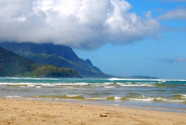 Hanalei Körfezi, Kauai, Hawaii 'deki dağları çevreleyen turkuaz sular. Bulutlar genişliyor ve dağın tepelerini kaplıyor..