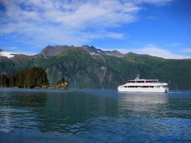 Tekne Prens William Sound 'daki Entrance Island' a doğru gidiyor. Chugach Dağları ve Anderson Buzulu Valdez, Alaska çevresindeki suları gezmek için güzel bir manzara sağlar..