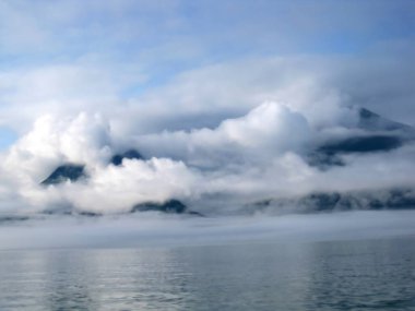Alaska Valdez Körfezi 'ndeki Chugach Dağları' nı kaplayan güzel yumuşak bulutlar. Mavi gökyüzü bulutlar kadar berrak görünür.