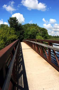 Çelik ve beton köprü Stoughton, Wisconsin 'deki Yahara Nehri Patikası' nda başlıyor. Köprü kavislenir ve uzaklarda kaybolur..