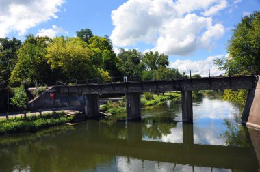 Yahara Nehri, Stoughton, Wisconsin 'deki Cooper Geçidi boyunca tren raylarının altından akar..