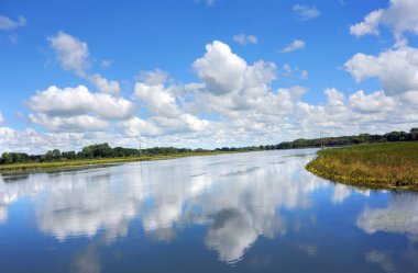 Yahara Nehri Yolu 'ndan manzara, nehrin huzurlu sularında gökyüzünün ve bulutların camsı yansımasını verir..