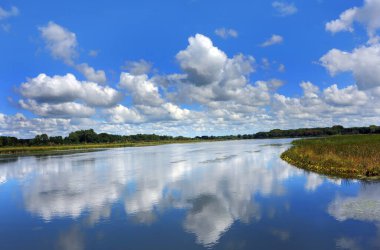 Yahara Nehri 'nin manzarası cam gibi pürüzsüz. Gökyüzü ve bulutların yansıması suyu maviye çevirir..