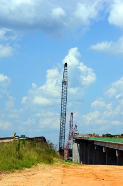 El Dorado, Arkansas yakınlarındaki Ouachita Nehri Köprüsü 'nün yerine inşaat devam ediyor. Uzun turnalar mavi gökyüzüne karşı duruyor.