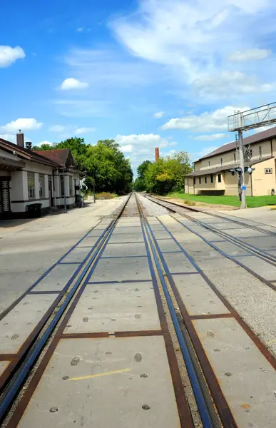 stock image Historic train depot sits besides railroad tracks in Stoughton, Wisconsin.  Tracks disappear into distance.