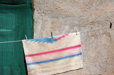 Adobe 'un evi çamaşır ipiyle kurutmak için eski yöntemleri kullanıyor. Hindistan 'dan esinlenilmiş halı kurumak üzere.