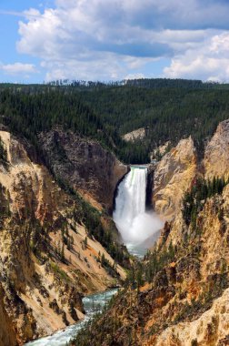 Yellowstone Ulusal Parkı 'ndaki Yellowstone' un Upper Falls manzarası. Yellowstone yolculuğuna devam ederken gök gürültülü sulardan büyük bir püskürme yükseliyor..