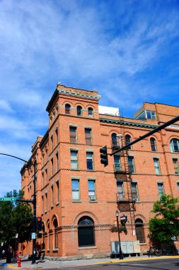 The Bozeman Hotel in Bozeman, Montana is Romanesque Revival architecture.  Image shows corner of building and arched windows on main street of town.   clipart