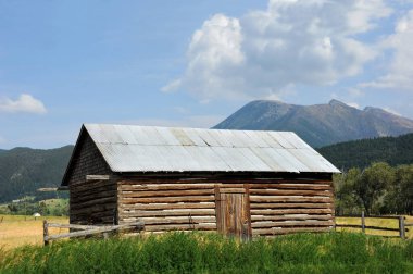 Etrafı çayırlarla, otlarla ve Montana 'nın Absaroka Dağları' yla çevrili ahşap kulübe..