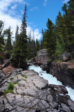 Montana 'daki Beartooth Manzarası yakınlarındaki Creek Falls Gölü manzarası. Şelalenin tepesi, granit duvarlar boyunca yokuş aşağı akıyor..