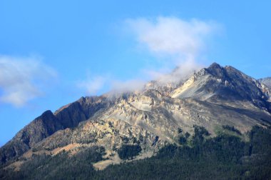 Montana 'daki engebeli göçmen tepesi mavi gökyüzü ve fısıldayan bulutlarla çevrilidir..