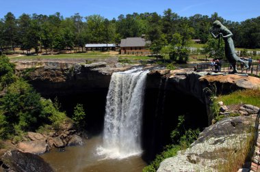 Noccalula Şelalesi, Appalachian Dağları 'ndaki Nocalula Şelalesi Parkı' nda turistler tarafından ziyaret edilir. Şelalenin üzerinden atlamak için koşan Cherokee Bakiresi heykeli resmedilmiş..