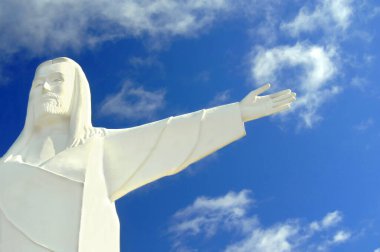 Eureka Springs 'te bulunan bir heykel olan Ozarks' lı İsa 'nın kolları açıktır. Mavi gökyüzü heykel arkasında.