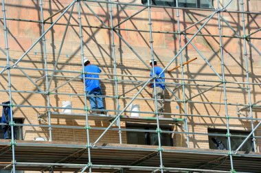 Şehir merkezindeki Asheville, Kuzey Carolina 'daki şehir binasının dış onarımında çalışan iki adam var..