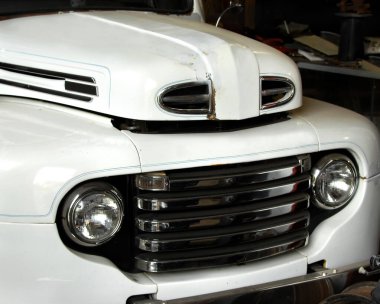 Antika Ford araba yenilenme sürecinde. Beyaz boya bir garajın içine sürülüyor..