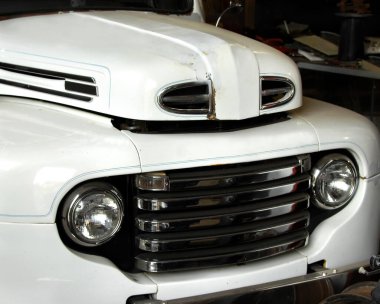 Antika Ford araba yenilenme sürecinde. Beyaz boya bir garajın içine sürülüyor..