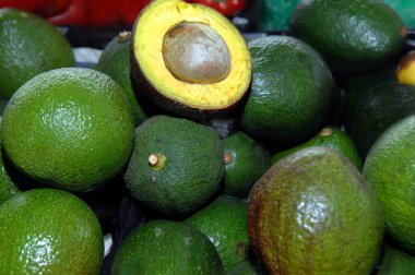 Bir avokado, 20 ya da daha fazla miktarda, meyve hamuru ve tohumu göstermek için ikiye bölündü..