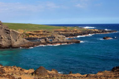 Hawaii 'nin büyük adası olan yeşil kumsalda kayalık ve engebeli sahil manzaraları var. Su mavisi sular, uzak ufka yaklaştıkça mavileşir..