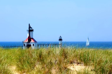 Yelkenli Michigan Gölü 'nün mavi sularında Michigan' daki St. Joseph Deniz fenerlerinin yanında yüzer..  