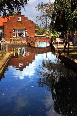 Bridge spans the small canal in Nelis Dutch Village in Holland, Michigan.  Village is a replica of a typical Dutch village. clipart