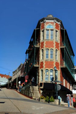 Hilly and twisty streets of Eureka Springs, Arkansas has historic buildings for visitors to tour.   clipart