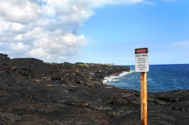 Tehlike, uzak dur, uçurumun kenarına asıldı. Hawaii Volkanları Ulusal Parkı ziyaretçileri Mauna Ulu patladığında oluşan sert kayalıkların tehlikeleri konusunda uyarıyor..  