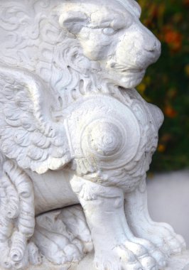 Elegant lion statuary guards a bed of yellow flowers at Maymont Gardens in Richmond, Virginia. clipart