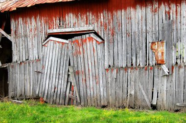Sarkık, çift kapılı bu köy ambarında menteşeleri zar zor duruyor. Ahşap yıpranır ve bir kez kırmızıya boyanır. Açılmış delikler iç kısımda çıplak tahtaları gösterir.