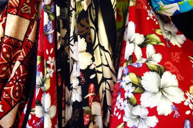 Parlak renkli kumaşlar, amber çiçekleri tasvir eder. Hediyelik gömlekler Hawaii adalarındaki her dükkanda satılıktır..