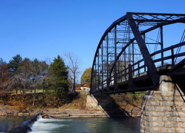 Tarihi Savaş Kartalı Mills Köprüsü, Arkansas 'ın kuzeyindeki War Eagle Nehri boyunca uzanır. Küçük şelale akan nehri yavaşlatmaya çalışır..