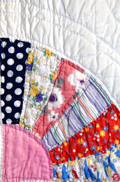 stock image Grandma's quilt has cotton pieced fabric forming a wheel pattern.  Image shows corner of wheel.