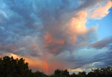 Phoenix, Arizona 'da günbatımı gökyüzünde gökkuşağı beliriyor. Mavi, pembe ve turuncuyla birleşir..