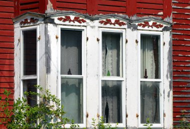 Yaşlanan Viktorya döneminden kalma ev kırmızı ve boyalı. Uyumlu, kırmızı ahşap, yapraklar pencere sazlıkları.