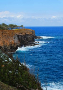 Alenuihaha kanalı Hawaii 'nin büyük adası boyunca masmavi. Dalgalar yüksek kayalıklara çarpar..