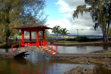 Liliuokalani is an authentic Japanese Garden in the town of Hilo on the Big Island of Hawaii.  the red tea house reflects on the lagoon waters. clipart