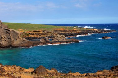 Hawaii 'nin büyük adası olan yeşil kumsalda kayalık ve engebeli sahil manzaraları var. Su mavisi sular, uzak ufka yaklaştıkça mavileşir..