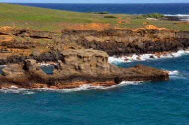 Green Sand Beach has rocky monoliths jutting out of aqua blue water.  Erosion from wind and waves have carved unusual rock formations. clipart