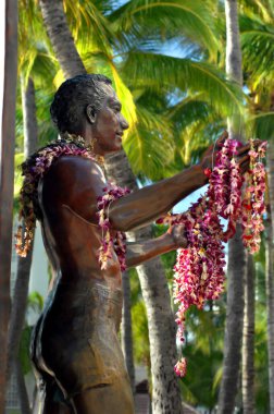 Dük Paoa Kahanamoku Waikiki 'nin kahramanlarından birinin anısına dikildi. Çiçek kolyeleri uzanmış ellerinden sarkıyor.  