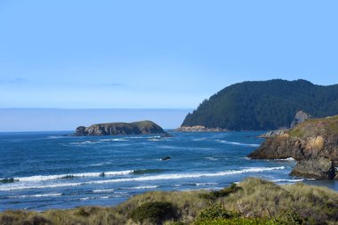 Oregon coast, along highway 101, yields views of blue ocean and off shore islands. clipart