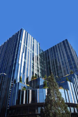 Portland, Oregon 'da çatısı olan modern bir bina. Mavi gökyüzü tepemizde.