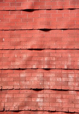 Yapının yanı kırmızı, tuğladan bir asbest yüzüyle kaplıdır..