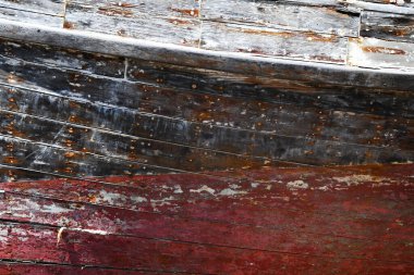 Arkaplan görüntüsü, eski ahşap bir teknenin dış görüntüsüdür. Kırmızı, siyah ve beyaz boya solmuş ve soyuluyor..  