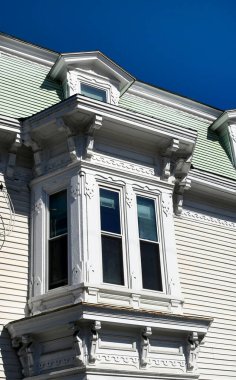 Güzel ahşap, bu beyaz Victoria evindeki pencere ve yatakhaneyi süslüyor..